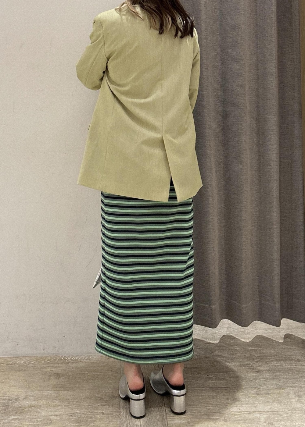 シルバー系のその他シューズ、グリーン系のテーラードジャケット、シルバー系のハンドバッグを着用したレディースの春コーディネートの5枚目の写真