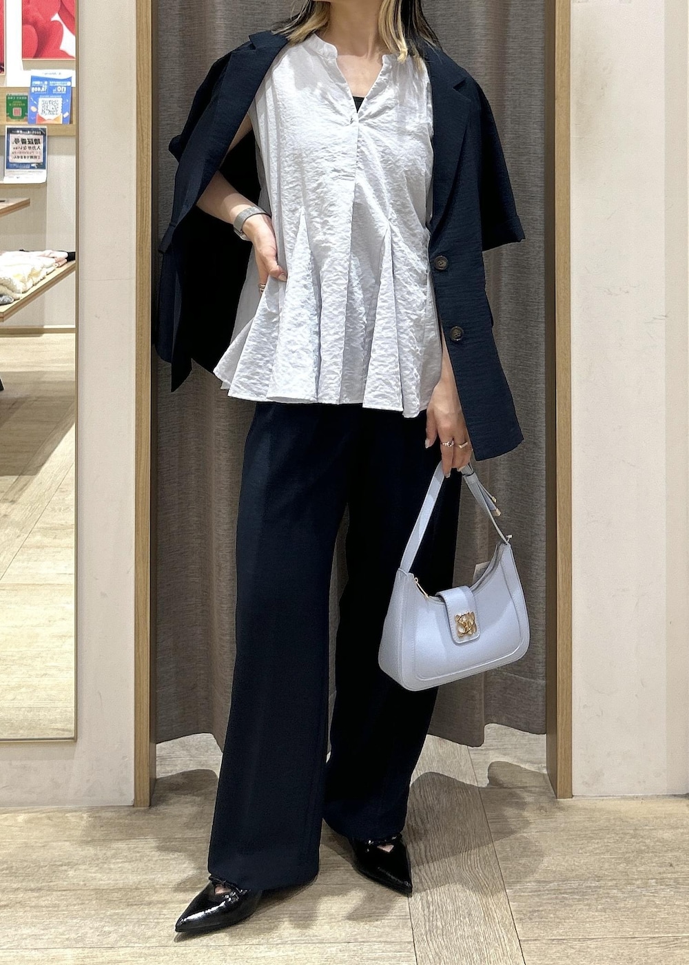ブルー系のハンドバッグ、ブラック系のパンプス、ブラック系のキャミソールを着用したレディースの夏コーディネートの5枚目の写真