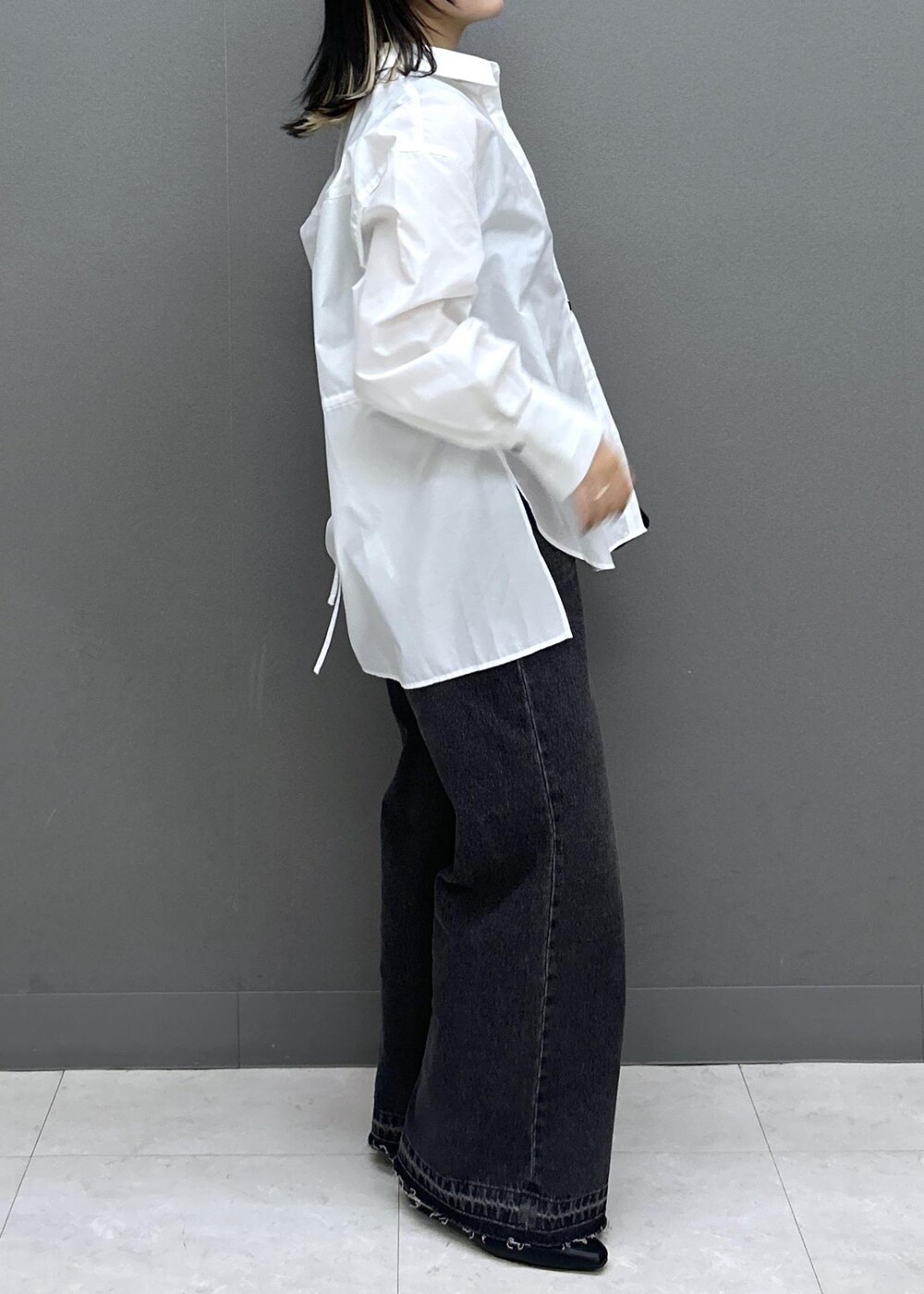 ブラック系のショルダーバッグ、ブラック系のパンプス、ブラック系のデニムパンツを着用したレディースの春コーディネートの7枚目の写真