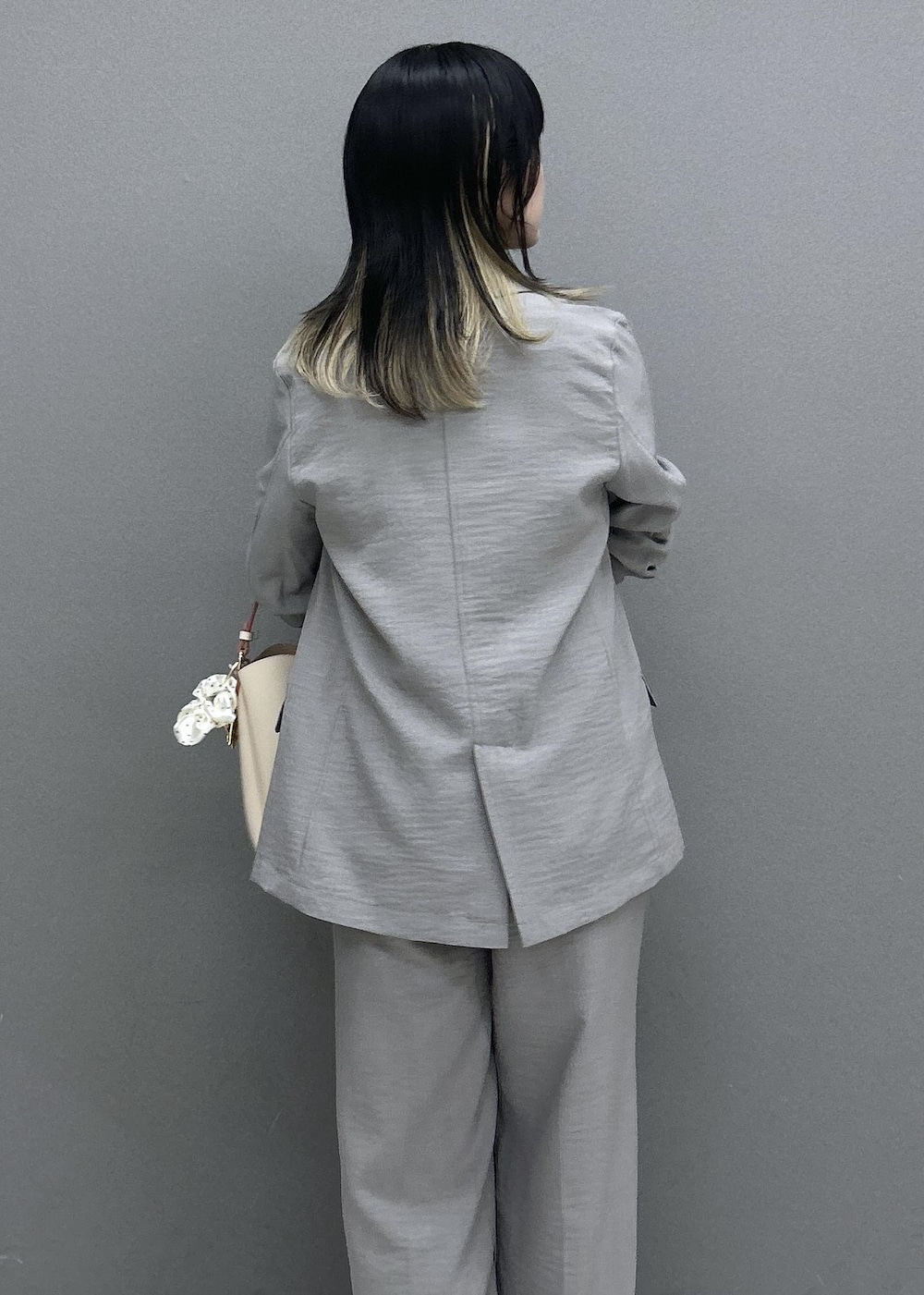 ベージュ系のショルダーバッグ、ホワイト系のパンプス、グレー系のTシャツ/カットソーを着用したレディースの夏コーディネートの9枚目の写真