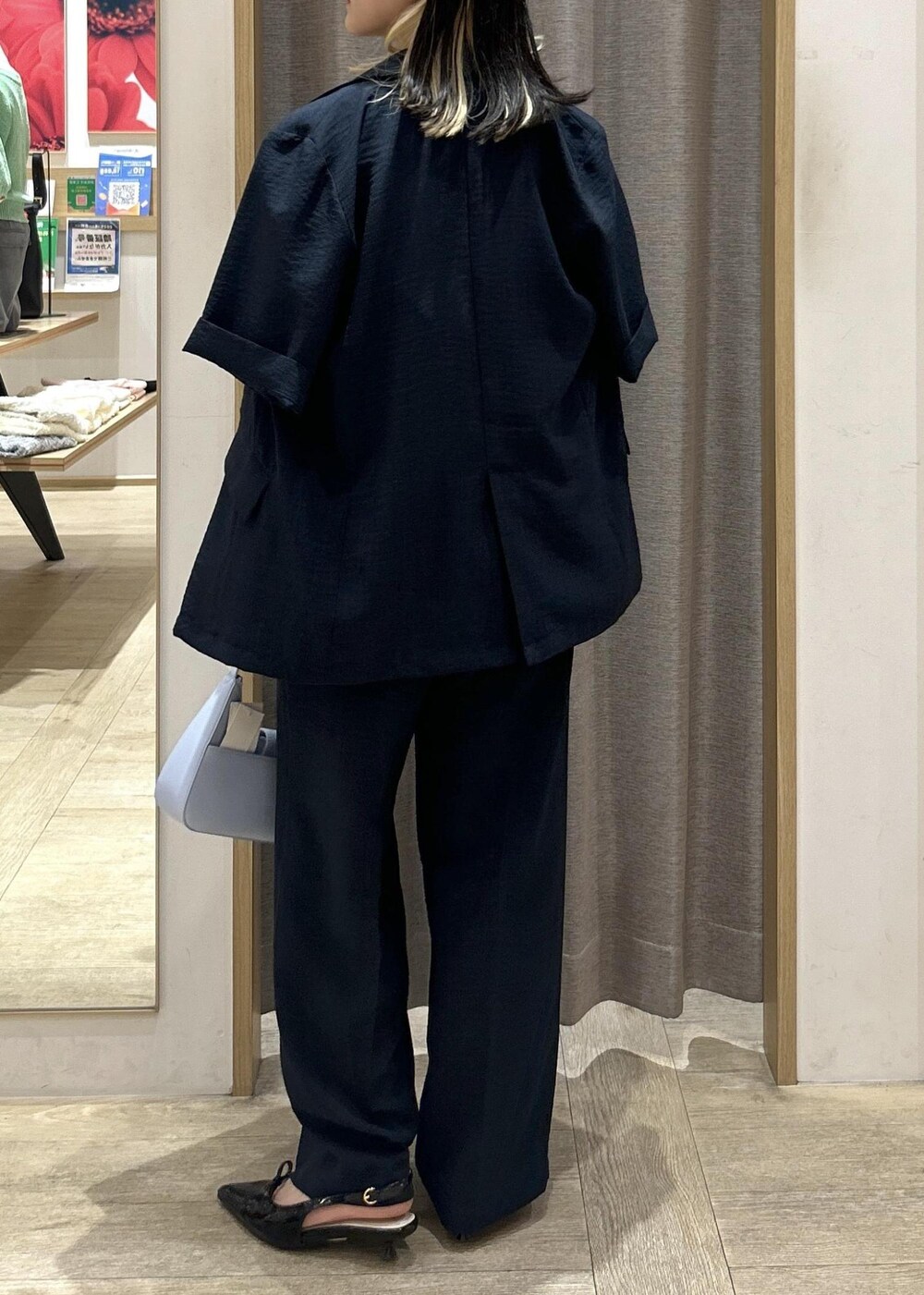 ブルー系のハンドバッグ、ブラック系のパンプス、ブラック系のキャミソールを着用したレディースの夏コーディネートの4枚目の写真
