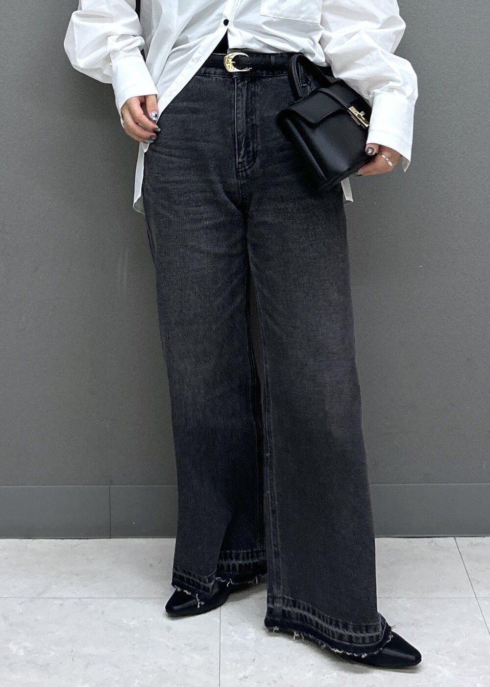 ブラック系のショルダーバッグ、ブラック系のパンプス、ブラック系のデニムパンツを着用したレディースの春コーディネートの10枚目の写真