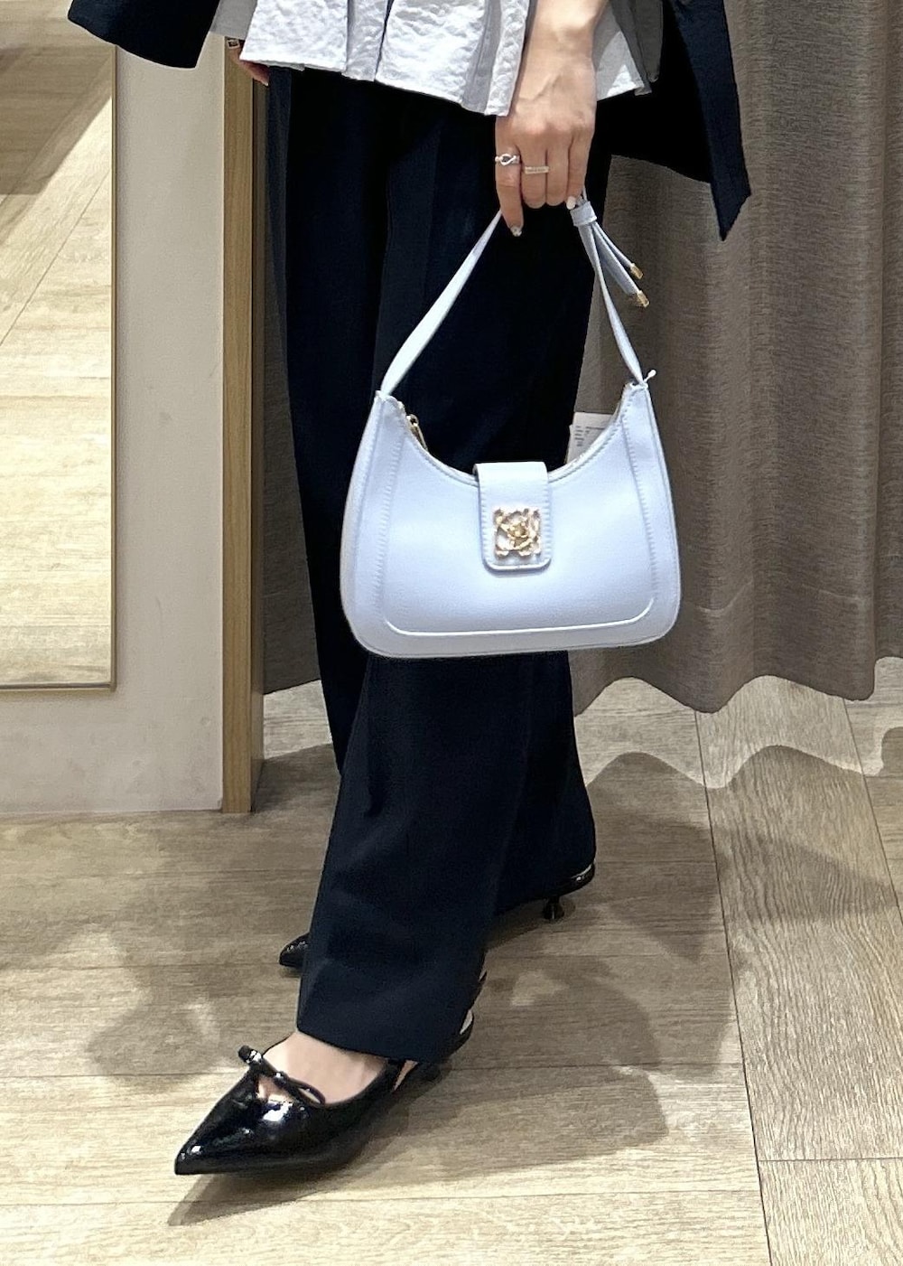 ブルー系のハンドバッグ、ブラック系のパンプス、ブラック系のキャミソールを着用したレディースの夏コーディネートの9枚目の写真