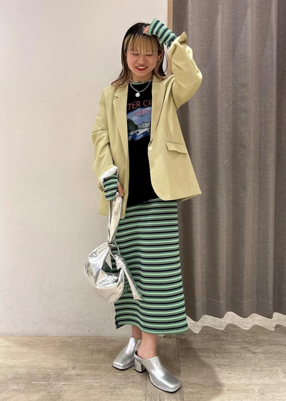 シルバー系のその他シューズ、グリーン系のテーラードジャケット、シルバー系のハンドバッグを着用したレディースの春コーディネートの2枚目の写真