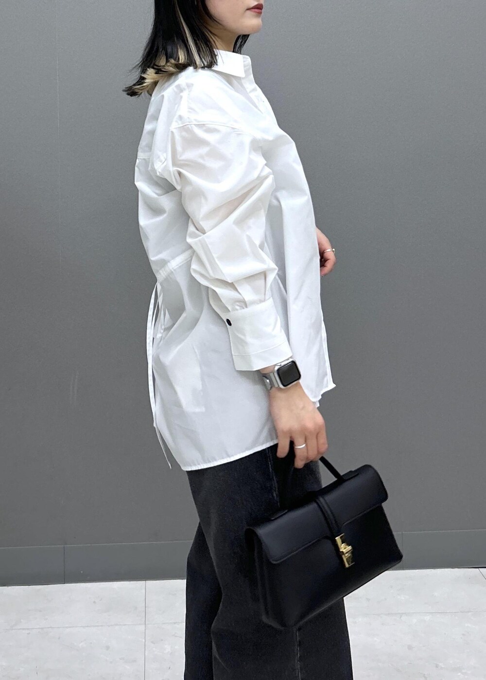 ブラック系のショルダーバッグ、ブラック系のパンプス、ブラック系のデニムパンツを着用したレディースの春コーディネートの9枚目の写真