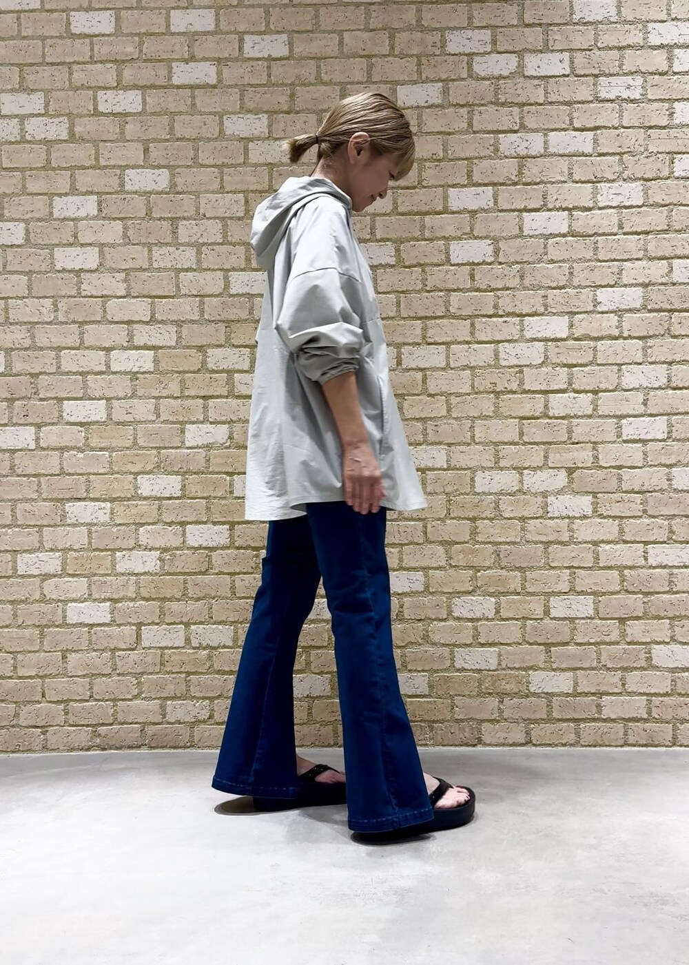 ブラック系のサンダル、グリーン系のパーカー、ブルー系のデニムパンツを着用したレディースの夏コーディネートの2枚目の写真