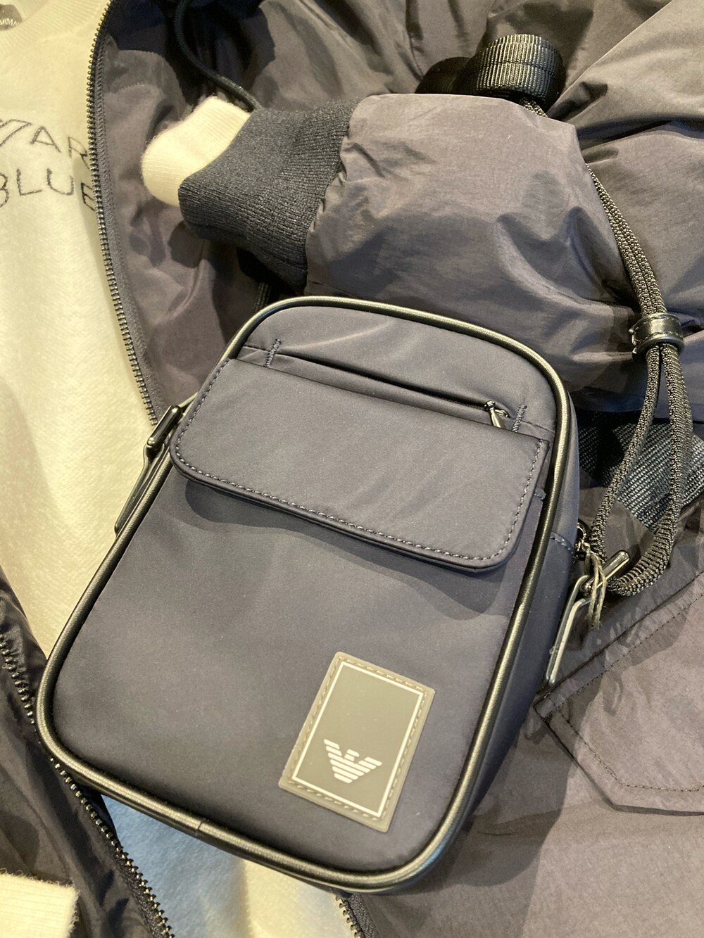 ブルー系のショルダーバッグ、ブルー系のダウンジャケット/コート、ブラック系のブーツを着用したレディースの秋コーディネートの4枚目の写真