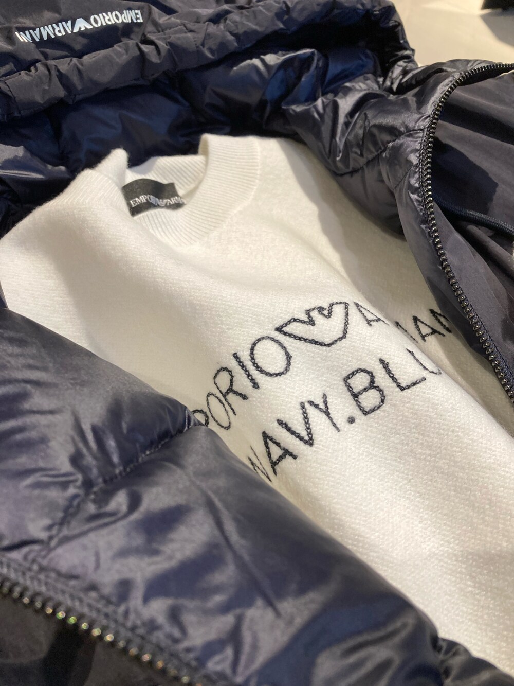 ブルー系のショルダーバッグ、ブルー系のダウンジャケット/コート、ブラック系のブーツを着用したレディースの秋コーディネートの3枚目の写真