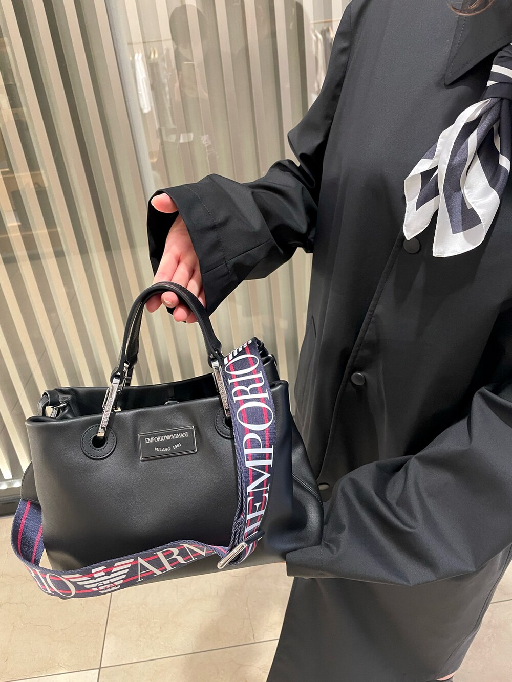 「EMPORIO ARMANI、エンポリオアルマーニ、モノトーン、モノトーンコーデ、メンズライク、メンズアイテム、スプリングコート、ブーツ、バッグ、レザー、スカーフ、ワンピース、白、黒、春のおしゃ見えテクニック」｜「EMPORIO ARMANIの【エンポリオ アルマーニ】MyEA ショッパー エコレザー製 スモール（ハンドバッグ、ブラック系）」を使った、airi naruseさん（レディース・157cm）の春コーディネートの2枚目の写真