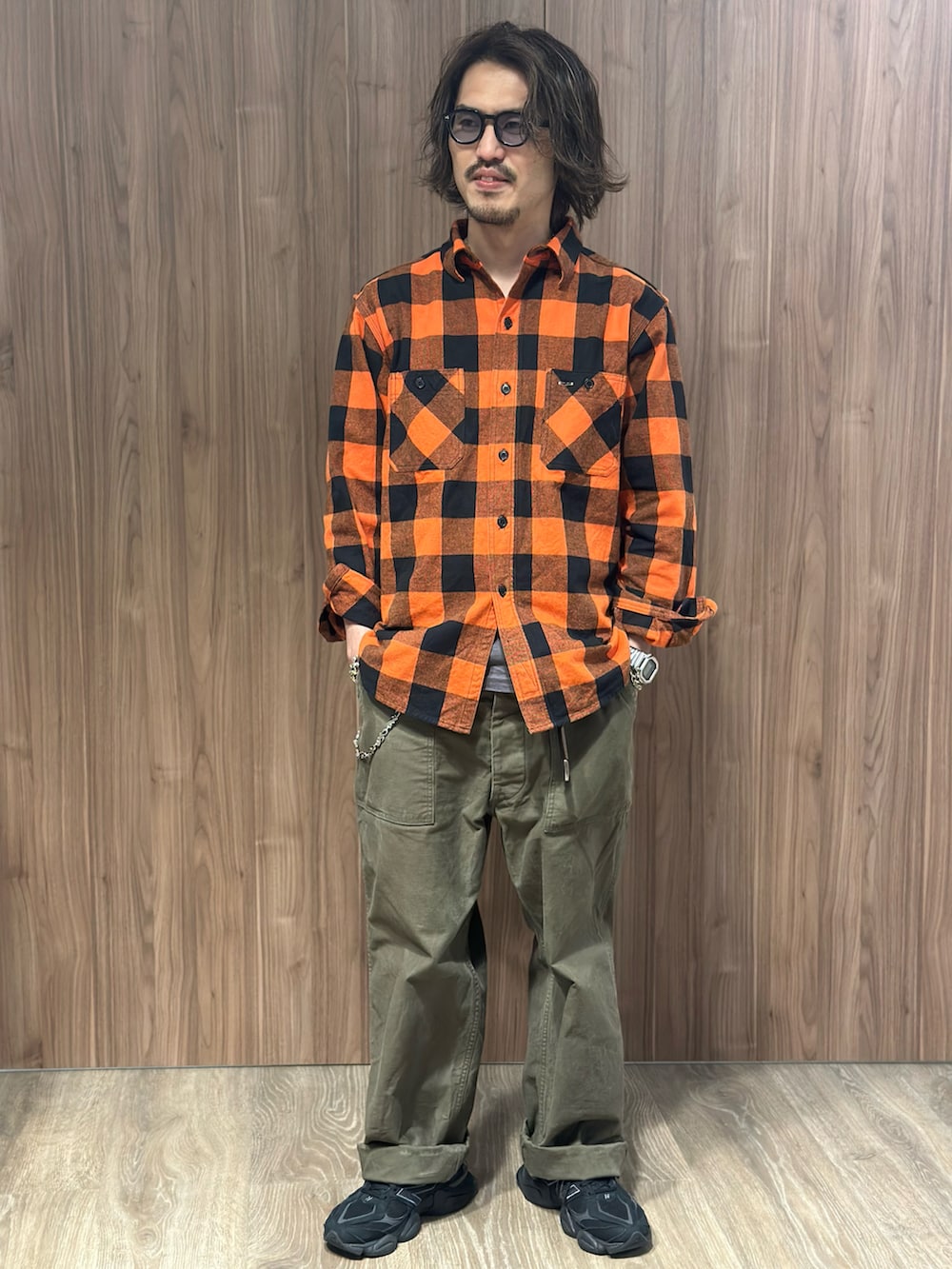 グリーン系のその他パンツ、オレンジ系のシャツ/ブラウス、ブラック系のスニーカーを着用したメンズの秋コーディネートの2枚目の写真