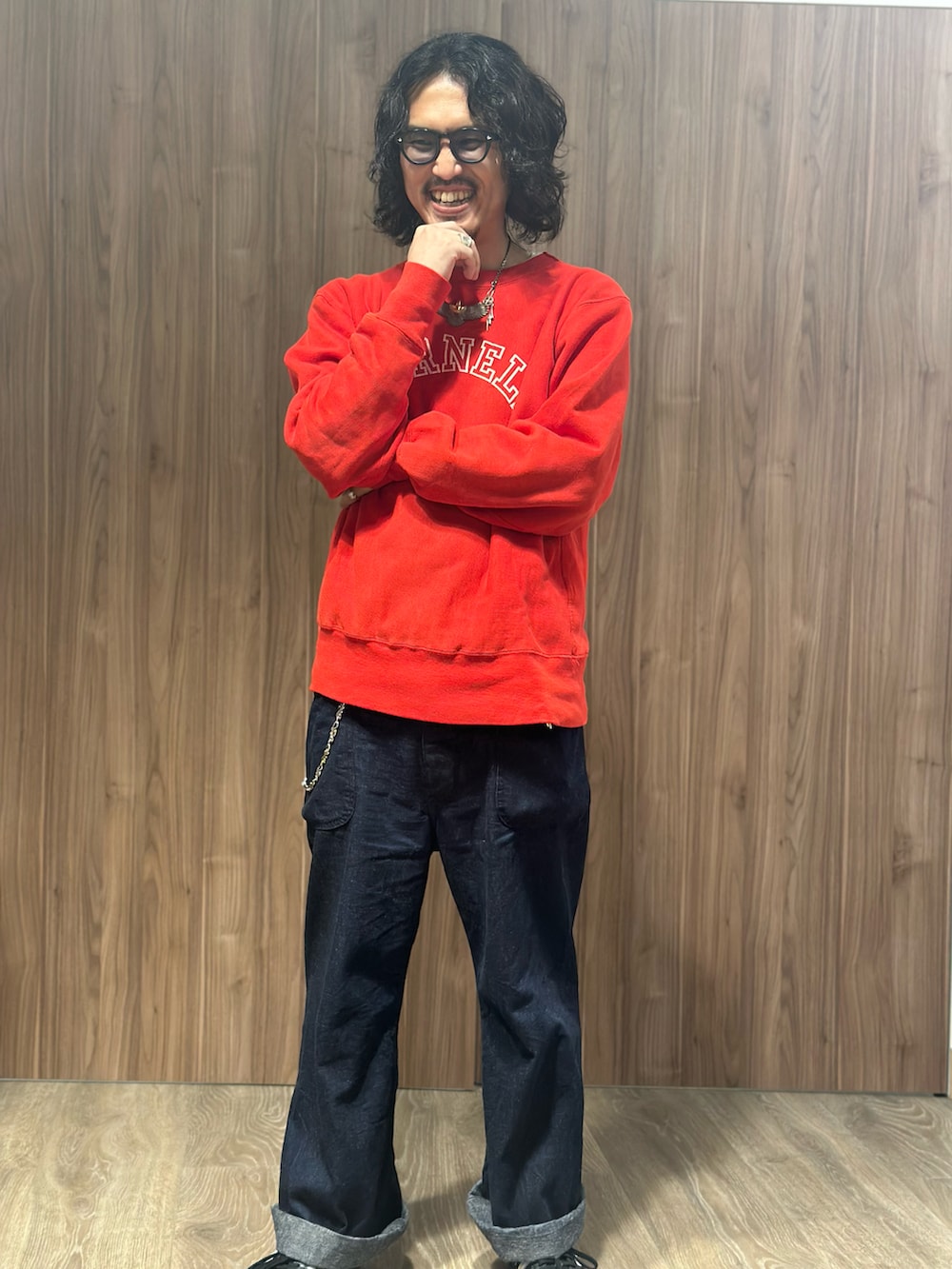 レッド系のスウェット、ブルー系のデニムパンツ、ブラック系のスニーカーを着用したメンズの冬コーディネートの2枚目の写真