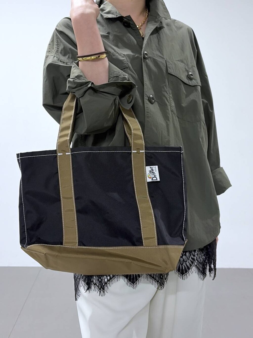 ホワイト系のスラックス、グリーン系のシャツ/ブラウス、ベージュ系のパンプスを着用したレディースの春コーディネートの5枚目の写真