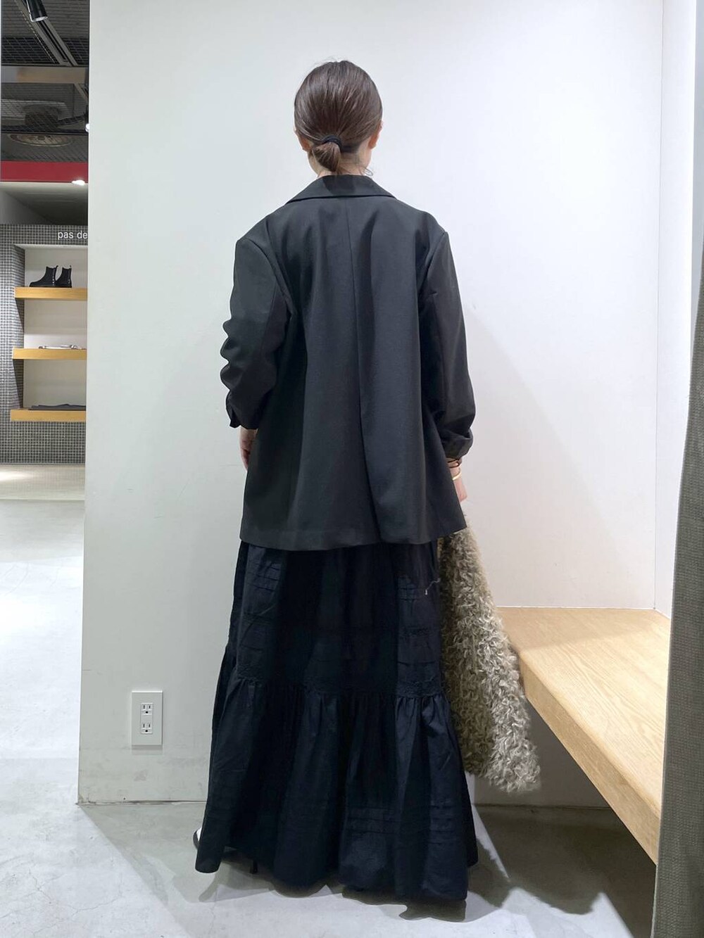 ブラック系のサンダル、ブラック系のテーラードジャケット、ブラック系のスカートを着用したレディースの秋コーディネートの3枚目の写真