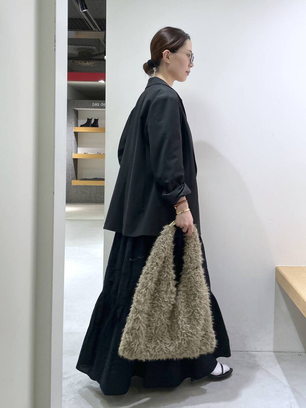 ブラック系のサンダル、ブラック系のテーラードジャケット、ブラック系のスカートを着用したレディースの秋コーディネートの2枚目の写真