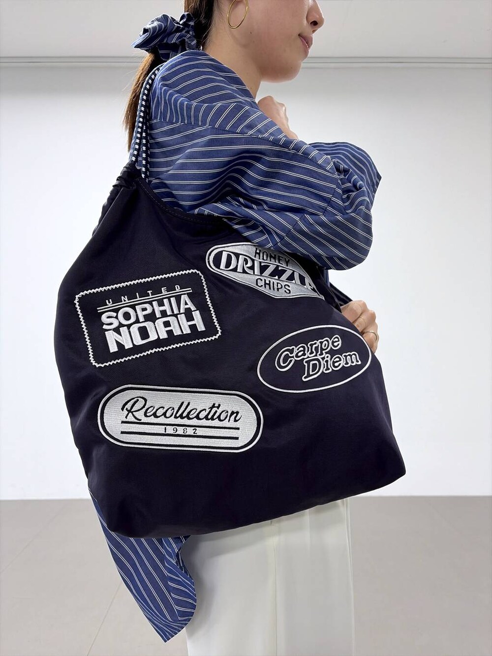 ホワイト系のスラックス、グレー系のローファー、ブルー系のシャツ/ブラウスを着用したレディースの春コーディネートの6枚目の写真