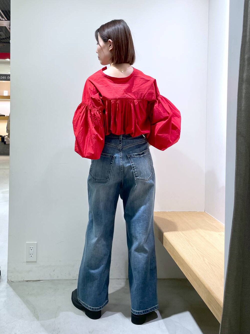 シルバー系のショルダーバッグ、ブルー系のデニムパンツ、ブラック系のブーツを着用したレディースの冬コーディネートの3枚目の写真