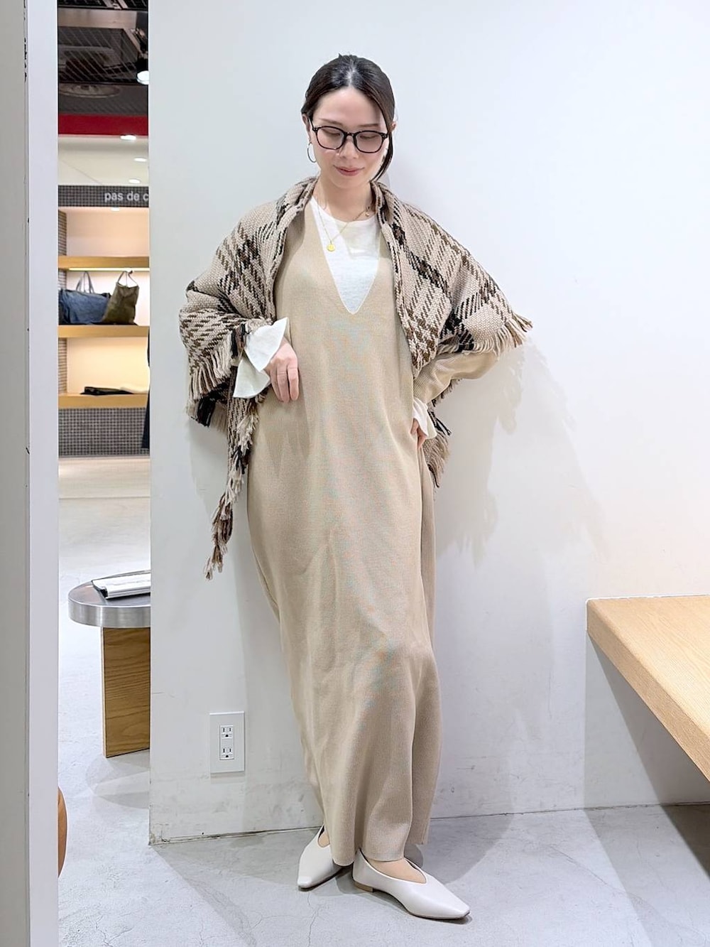 ホワイト系のニット/セーター、ベージュ系のワンピース、ブラウン系のハンドバッグを着用したレディースの冬コーディネートの4枚目の写真