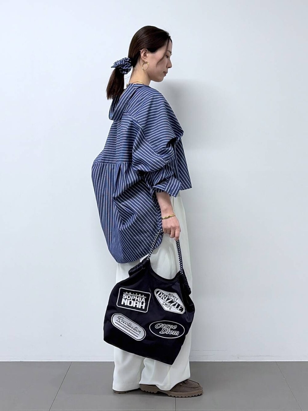 ホワイト系のスラックス、グレー系のローファー、ブルー系のシャツ/ブラウスを着用したレディースの春コーディネートの2枚目の写真