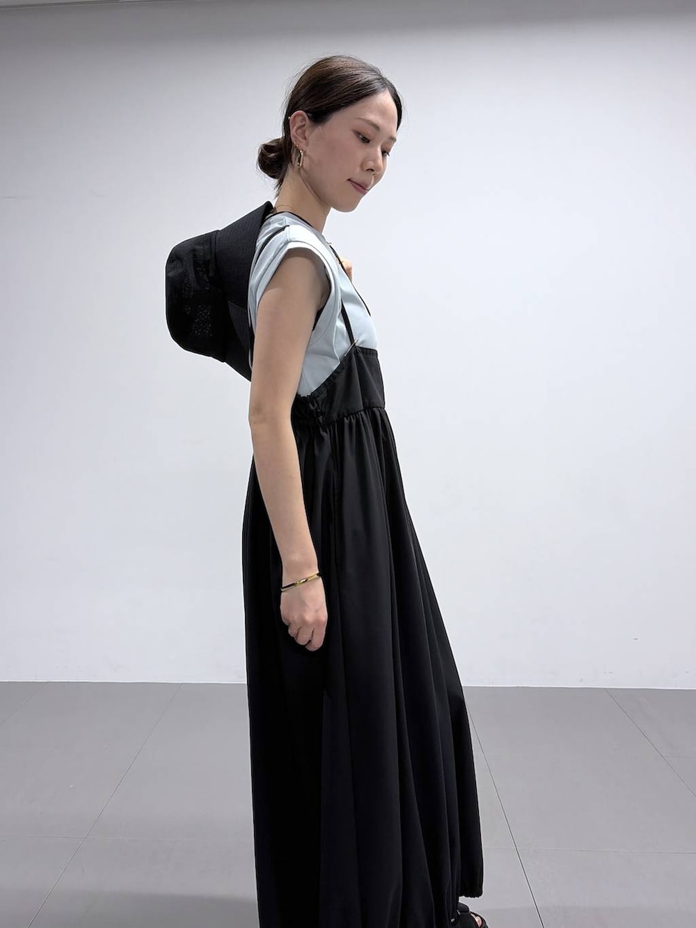 グリーン系のTシャツ/カットソー、ブラック系のサンダル、ブラック系のハットを着用したレディースの春コーディネートの6枚目の写真