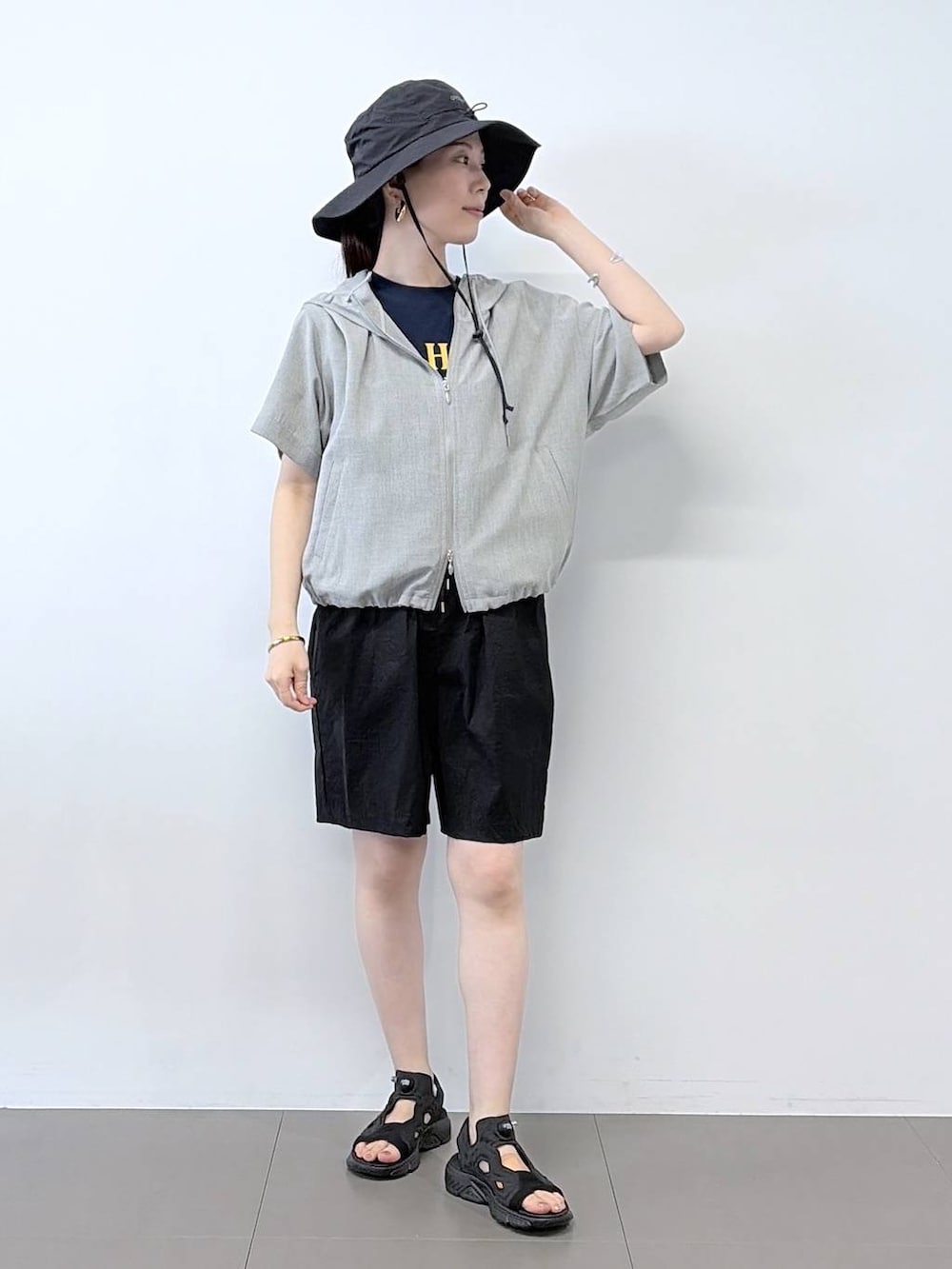 ブルー系のTシャツ/カットソー、ブラック系のその他パンツ、グレー系のブルゾンを着用したレディースの夏コーディネートの2枚目の写真