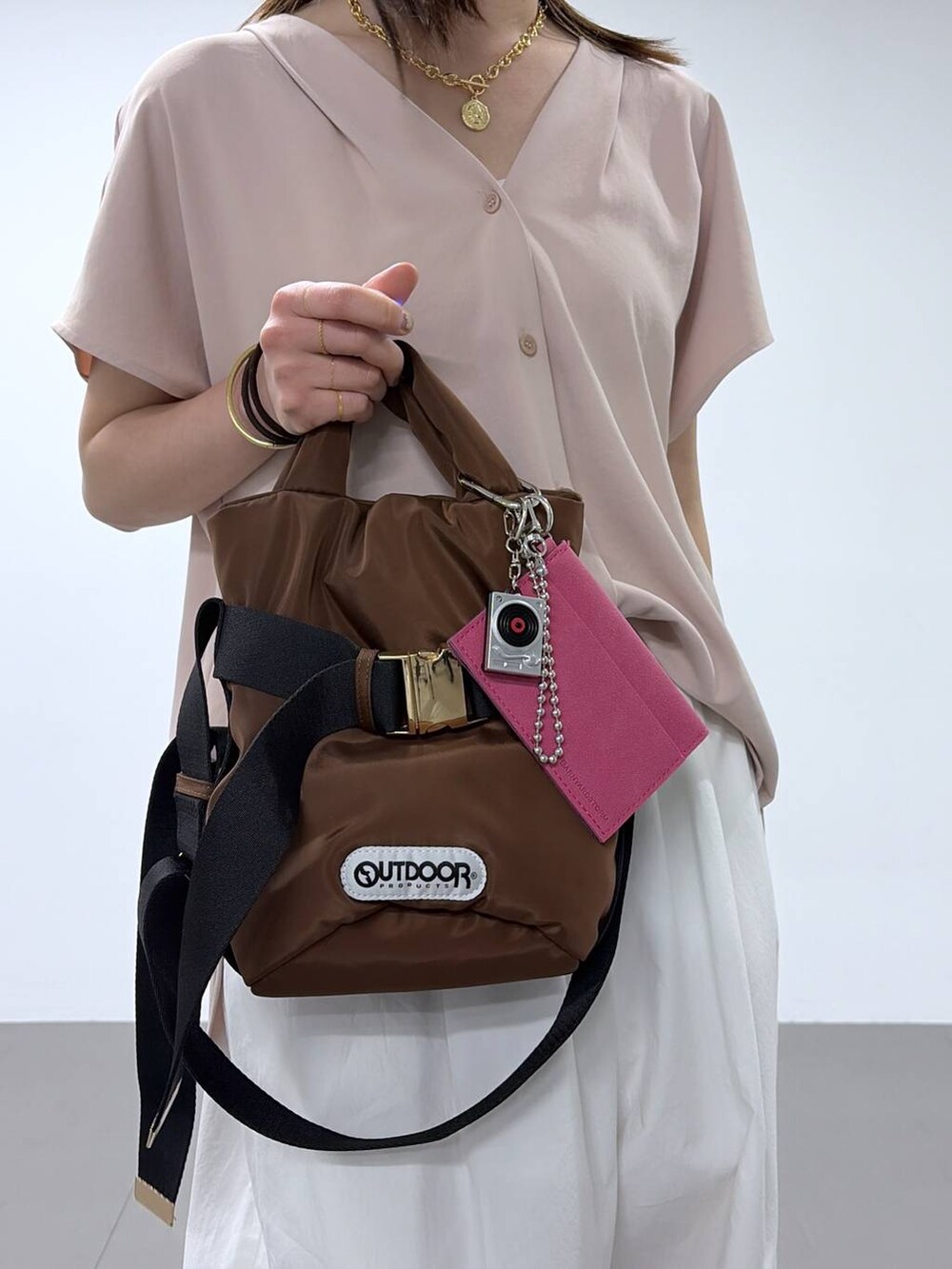 ブラウン系のショルダーバッグ、ホワイト系のその他パンツ、ピンク系のシャツ/ブラウスを着用したレディースの春コーディネートの6枚目の写真