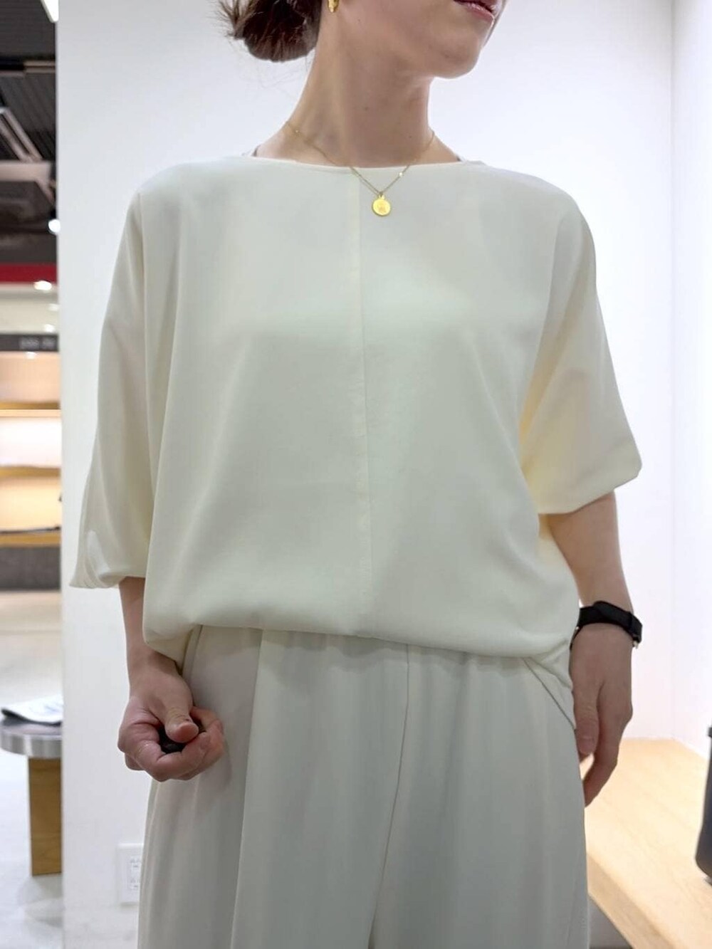 ホワイト系のキャミソール、ホワイト系のスラックス、ホワイト系のTシャツ/カットソーを着用したレディースの冬コーディネートの6枚目の写真