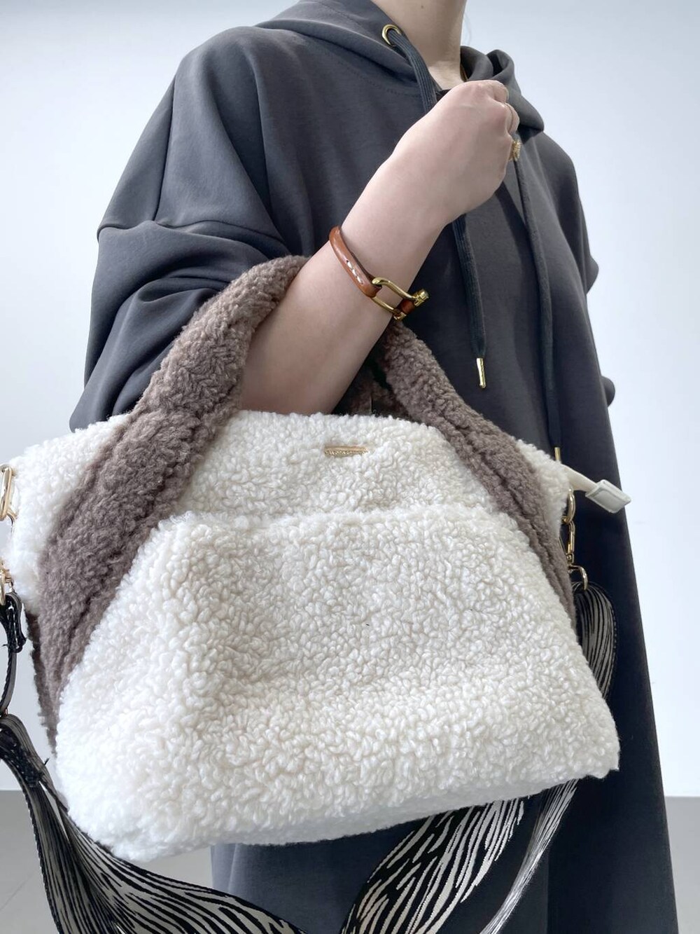 グレー系のワンピース、ホワイト系のトートバッグを着用したレディースの秋コーディネートの6枚目の写真