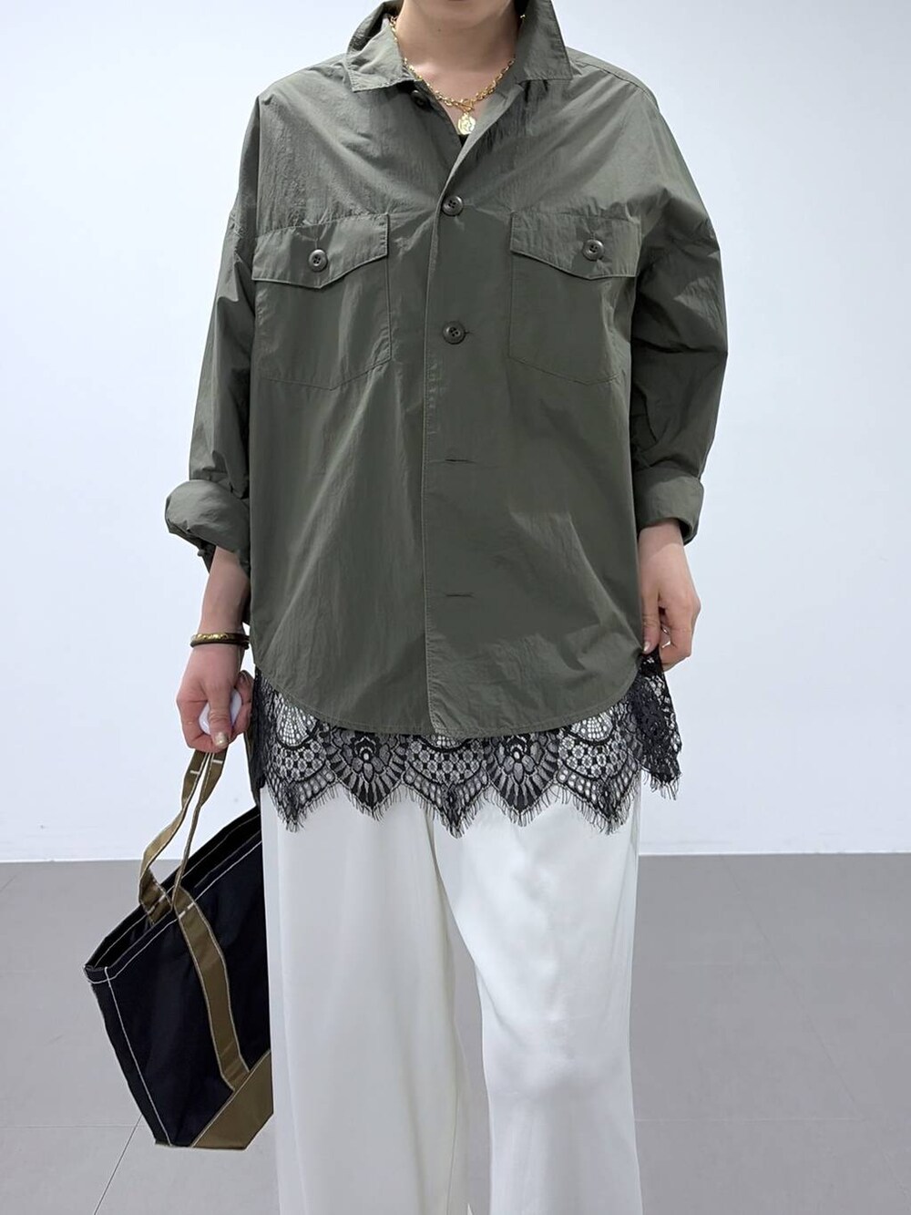 ホワイト系のスラックス、グリーン系のシャツ/ブラウス、ベージュ系のパンプスを着用したレディースの春コーディネートの4枚目の写真