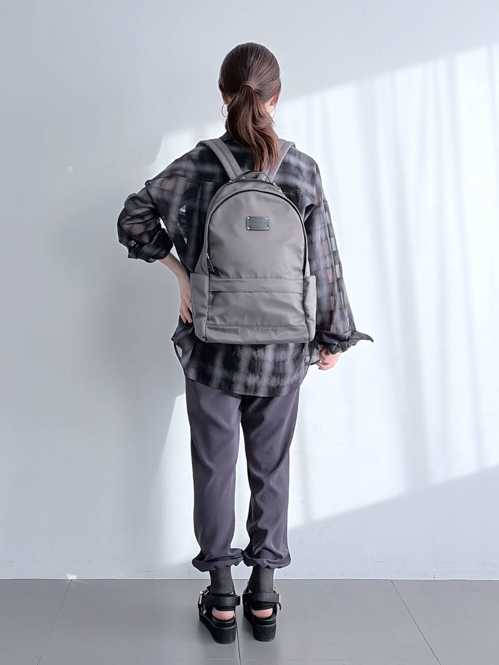 グレー系のバックパック/リュック、ブラック系のサンダル、ブラック系のシャツ/ブラウスを着用したレディースの夏コーディネートの7枚目の写真