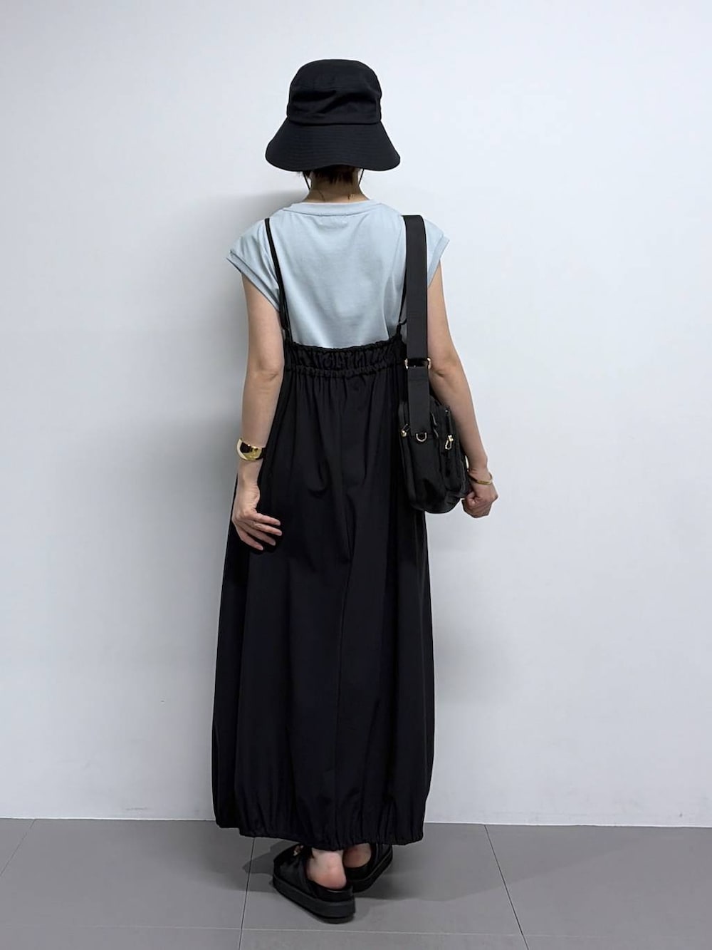 グリーン系のTシャツ/カットソー、ブラック系のサンダル、ブラック系のハットを着用したレディースの春コーディネートの3枚目の写真