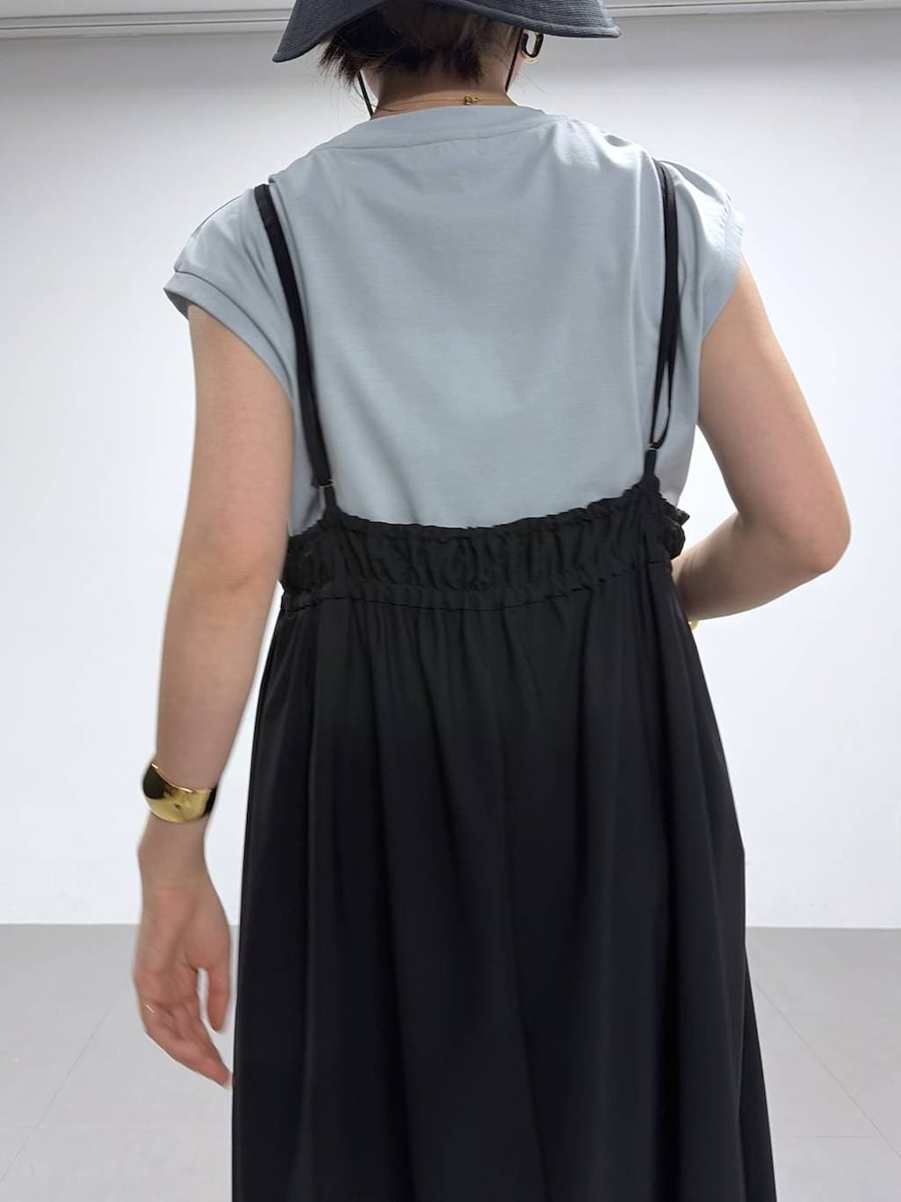 グリーン系のTシャツ/カットソー、ブラック系のサンダル、ブラック系のハットを着用したレディースの春コーディネートの7枚目の写真