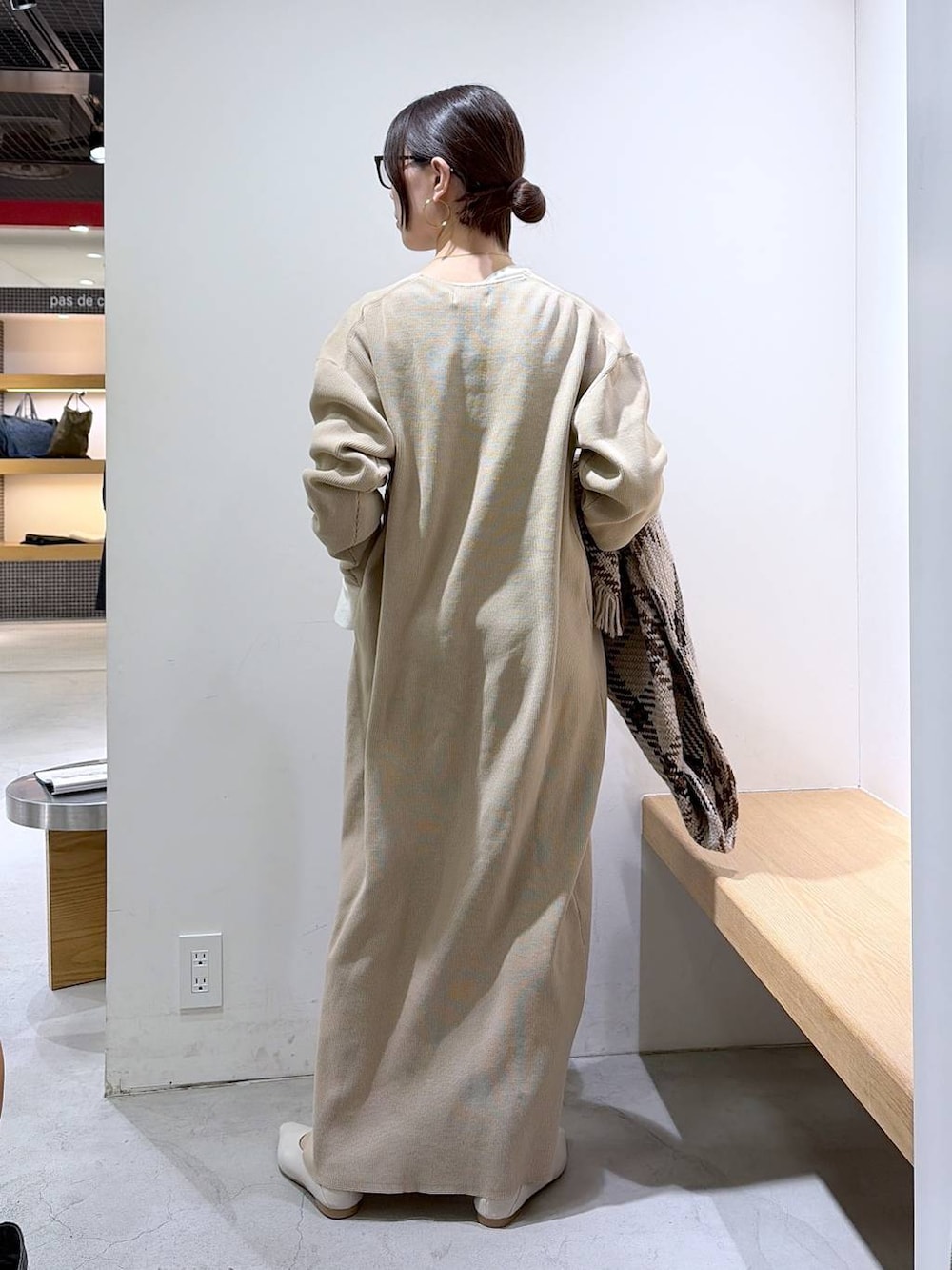 ホワイト系のニット/セーター、ベージュ系のワンピース、ブラウン系のハンドバッグを着用したレディースの冬コーディネートの3枚目の写真