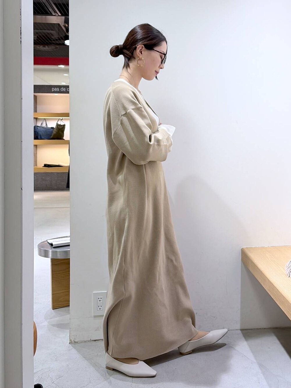 ホワイト系のニット/セーター、ベージュ系のワンピース、ブラウン系のハンドバッグを着用したレディースの冬コーディネートの5枚目の写真