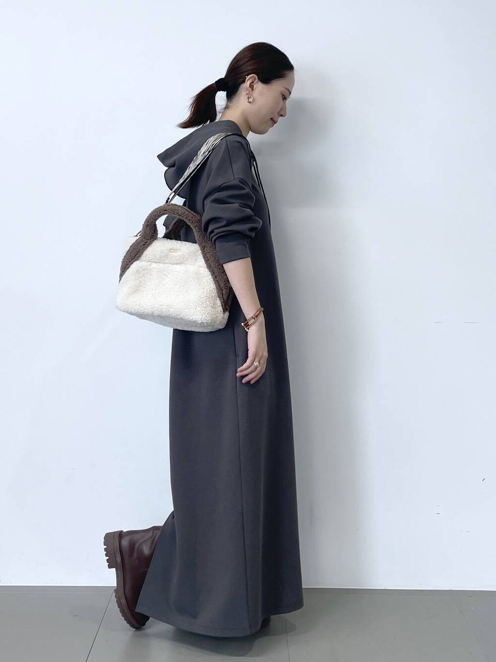 グレー系のワンピース、ホワイト系のトートバッグを着用したレディースの秋コーディネートの4枚目の写真