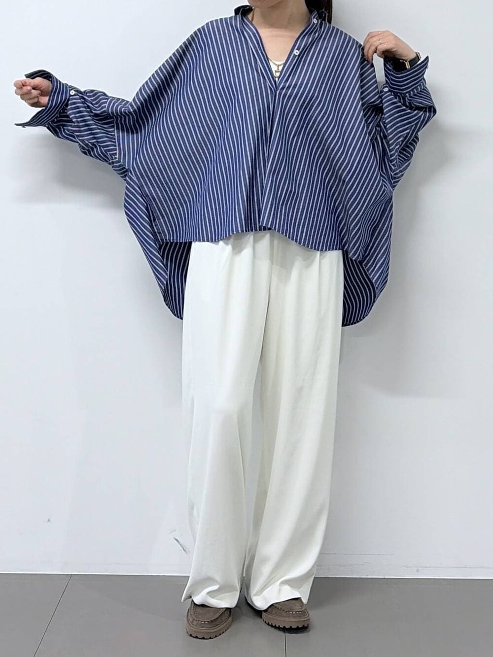 ホワイト系のスラックス、グレー系のローファー、ブルー系のシャツ/ブラウスを着用したレディースの春コーディネートの4枚目の写真