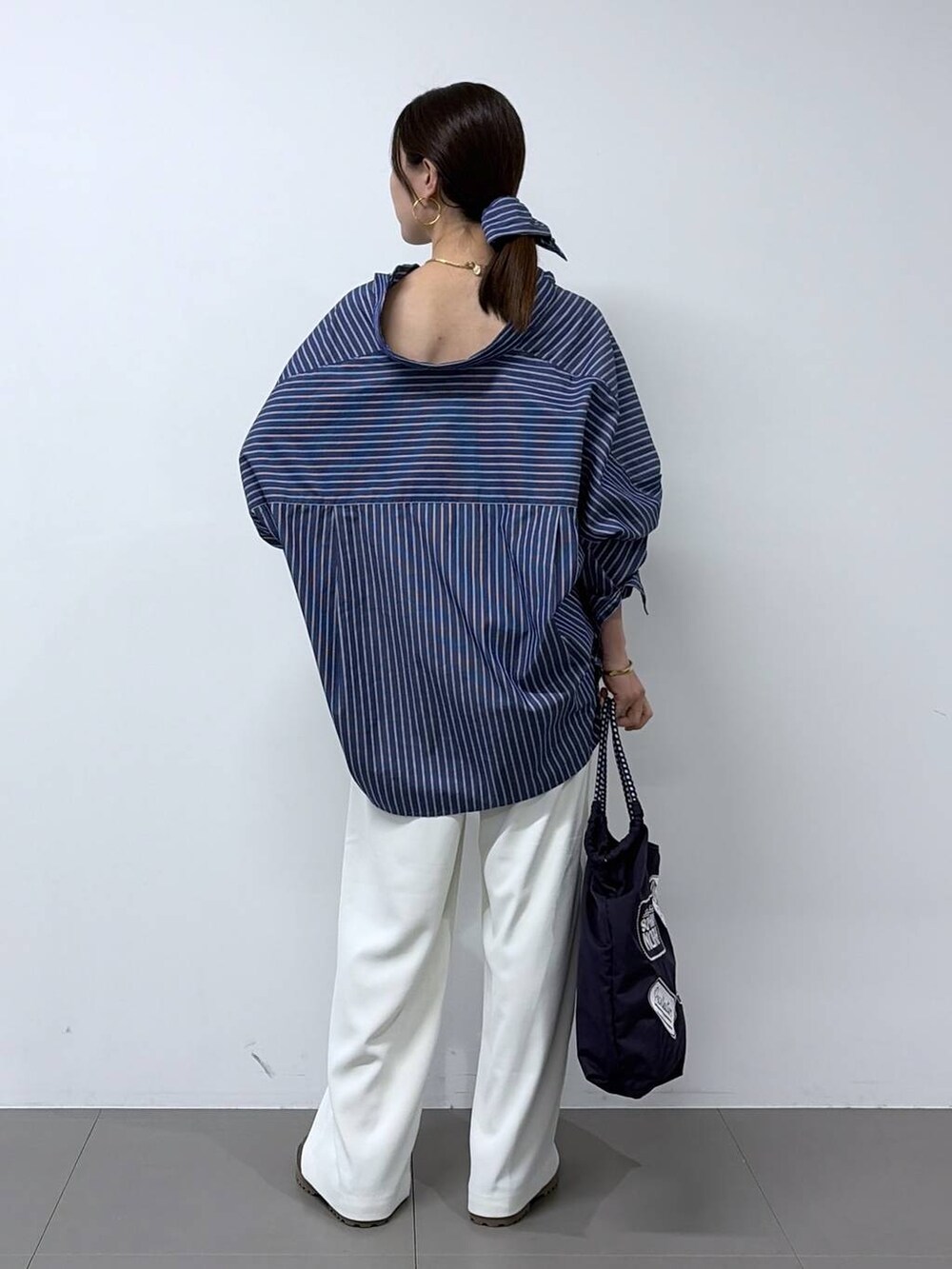 ホワイト系のスラックス、グレー系のローファー、ブルー系のシャツ/ブラウスを着用したレディースの春コーディネートの3枚目の写真