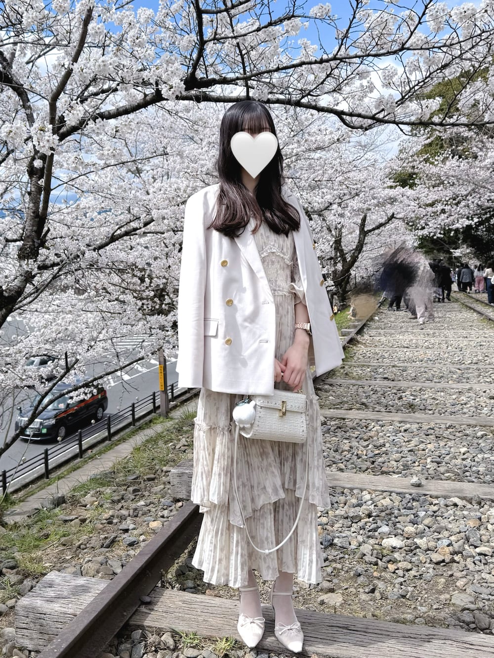 ベージュ系のワンピース、ホワイト系のショルダーバッグ、ベージュ系のパンプスを着用したレディースの春コーディネートの2枚目の写真