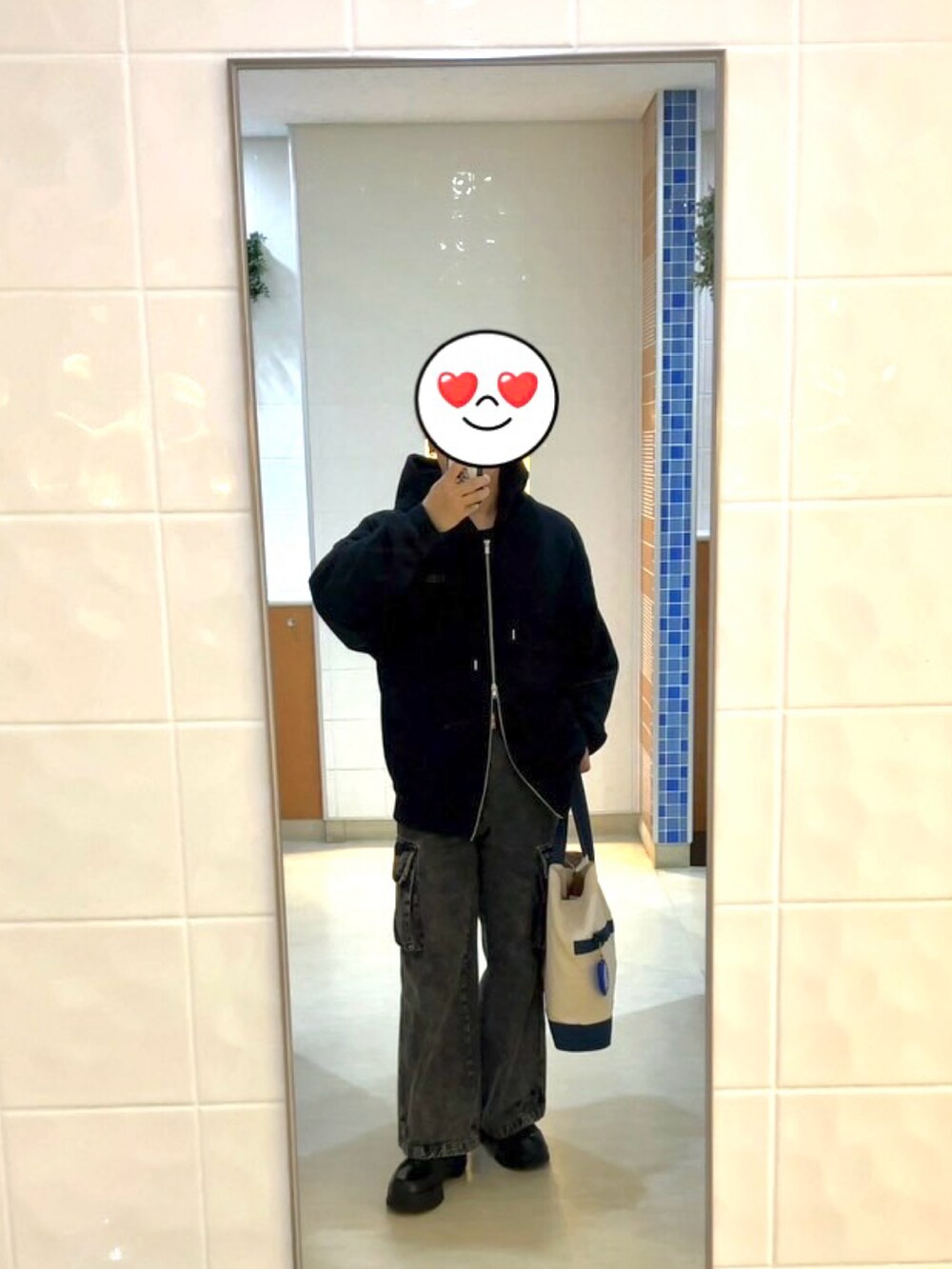 ブラック系のカーゴパンツ、ブラック系のスニーカー、ブラック系のパーカーを着用したメンズの春コーディネートの2枚目の写真