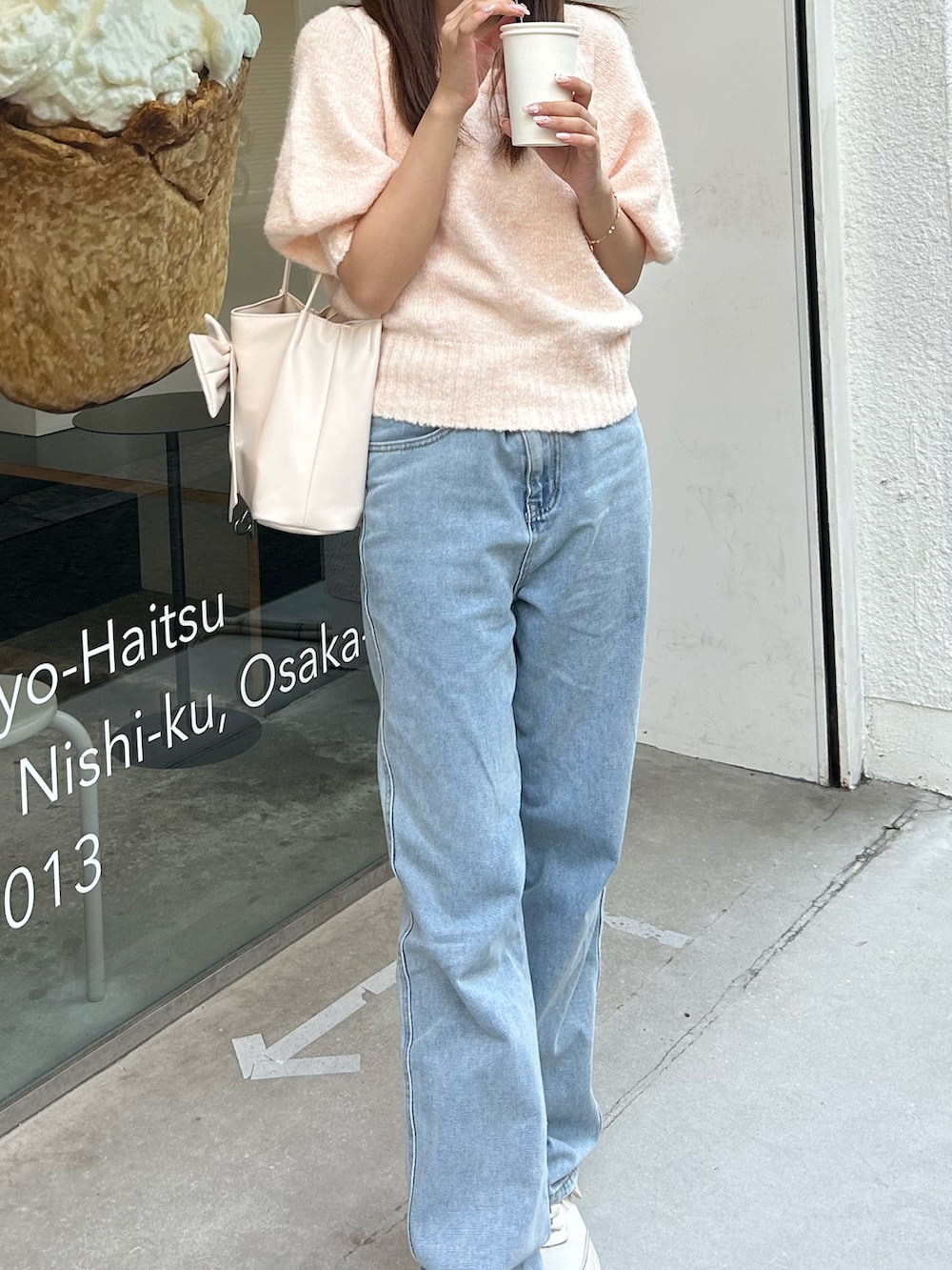 その他のデニムパンツ、ピンク系のニット/セーター、ホワイト系のハンドバッグを着用したレディースの秋コーディネートの2枚目の写真