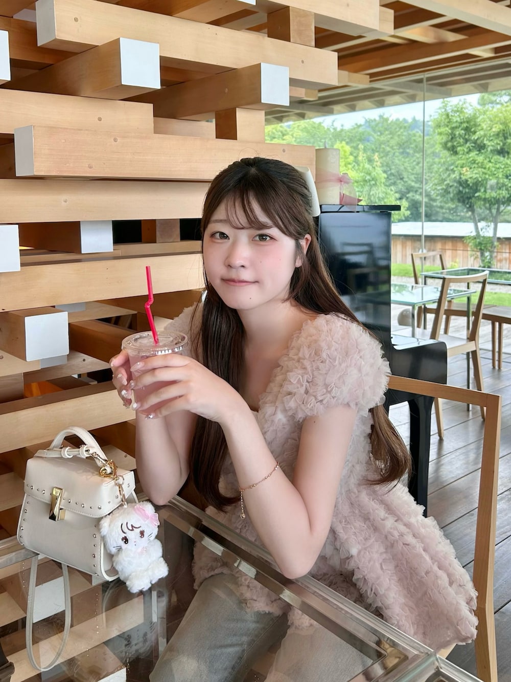 ピンク系のシャツ/ブラウス、ホワイト系のショルダーバッグを着用したレディースの夏コーディネートの2枚目の写真