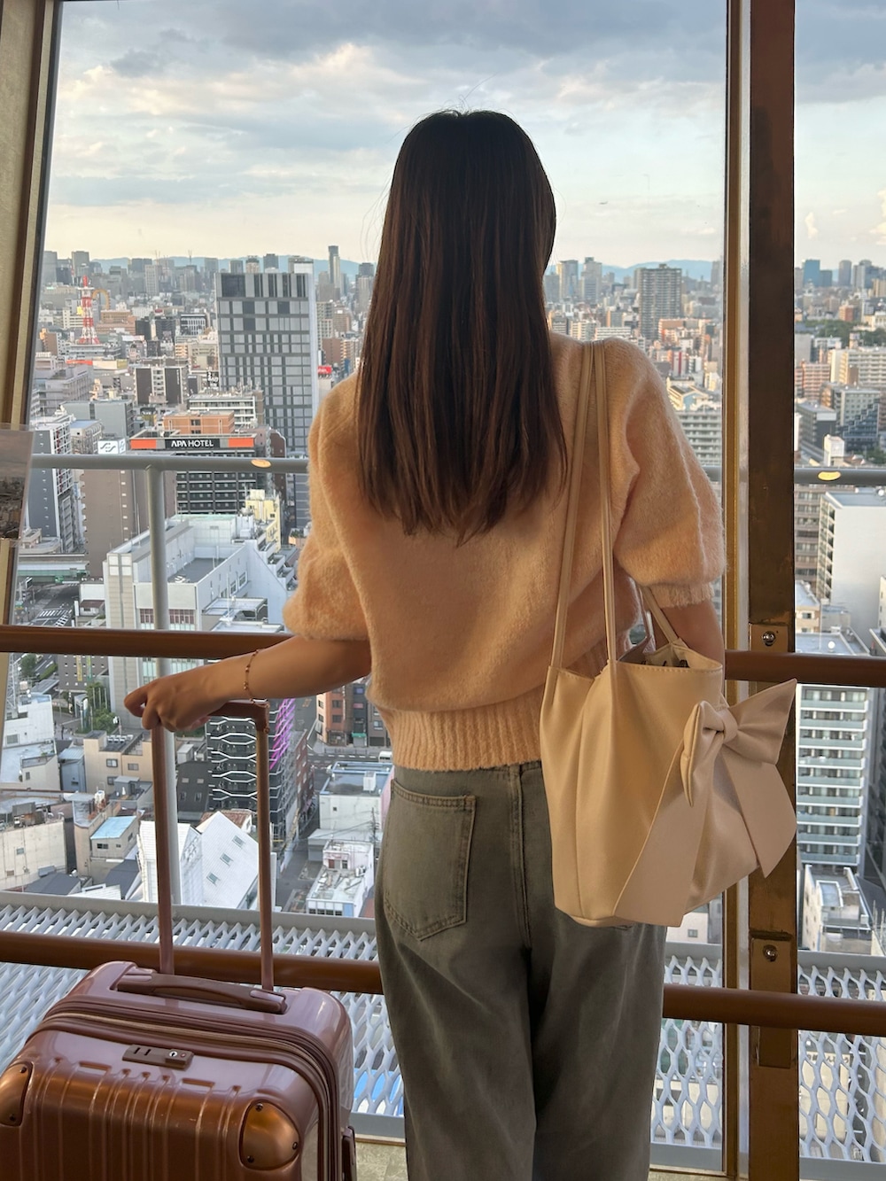 その他のデニムパンツ、ピンク系のニット/セーター、ホワイト系のハンドバッグを着用したレディースの秋コーディネートの3枚目の写真