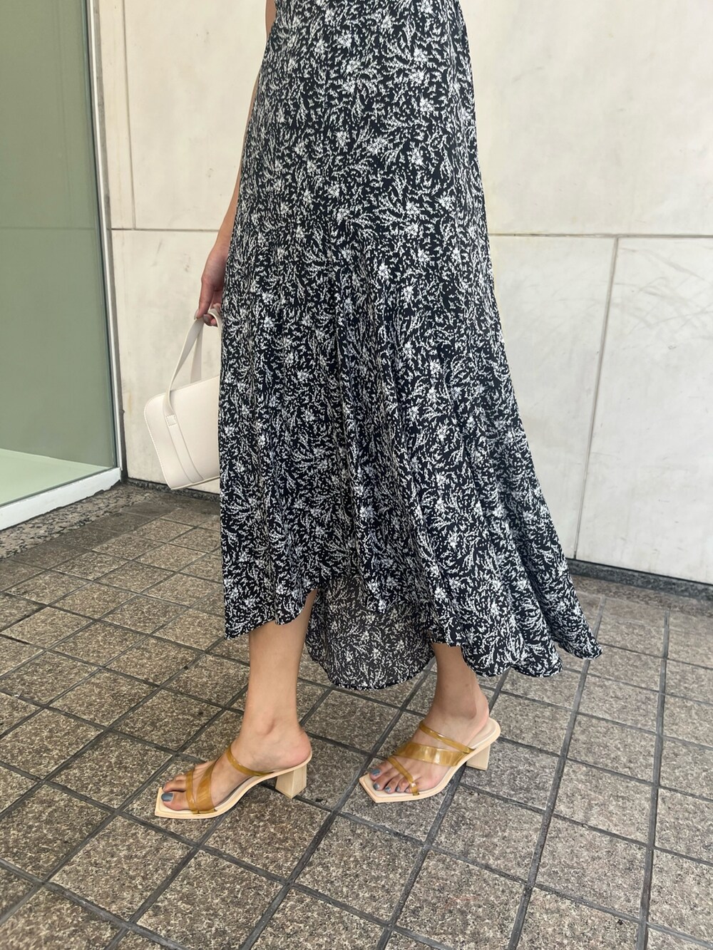 ブラック系のワンピース、ホワイト系のショルダーバッグを着用したレディースの夏コーディネートの7枚目の写真