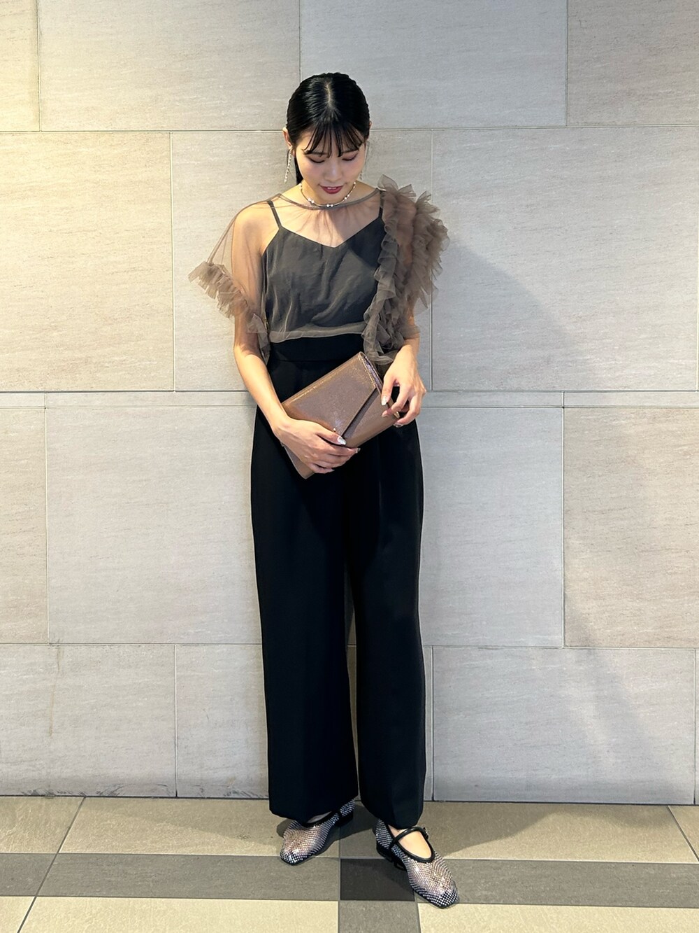 ゴールド系のクラッチバッグ、ブラック系のパンプス、その他のパンツドレスを着用したレディースの秋コーディネートの2枚目の写真