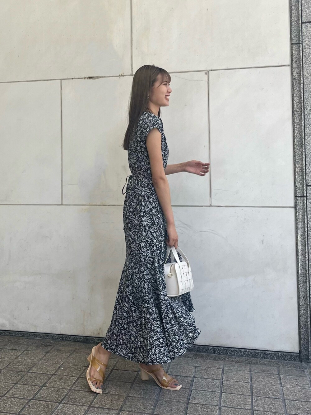 ブラック系のワンピース、ホワイト系のショルダーバッグを着用したレディースの夏コーディネートの3枚目の写真