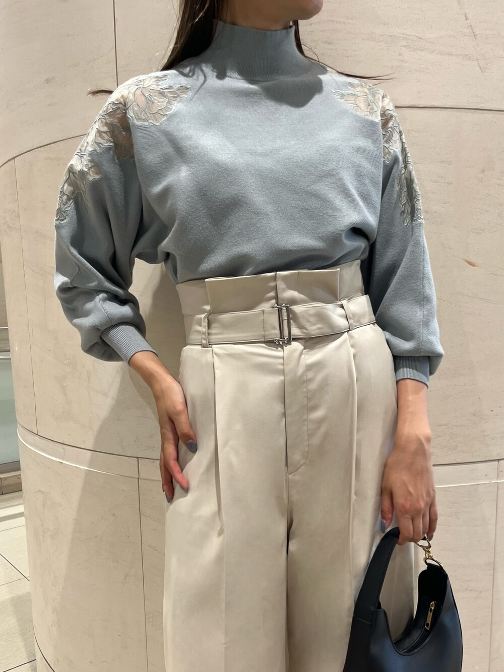 グリーン系のニット/セーター、ホワイト系のその他パンツ、ブラック系のハンドバッグを着用したレディースの秋コーディネートの5枚目の写真