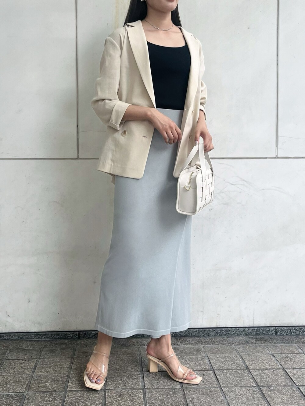 ブルー系のスカート、ホワイト系のショルダーバッグ、ベージュ系のテーラードジャケットを着用したレディースの夏コーディネートの5枚目の写真