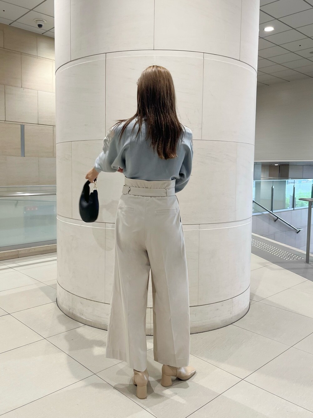 グリーン系のニット/セーター、ホワイト系のその他パンツ、ブラック系のハンドバッグを着用したレディースの秋コーディネートの4枚目の写真