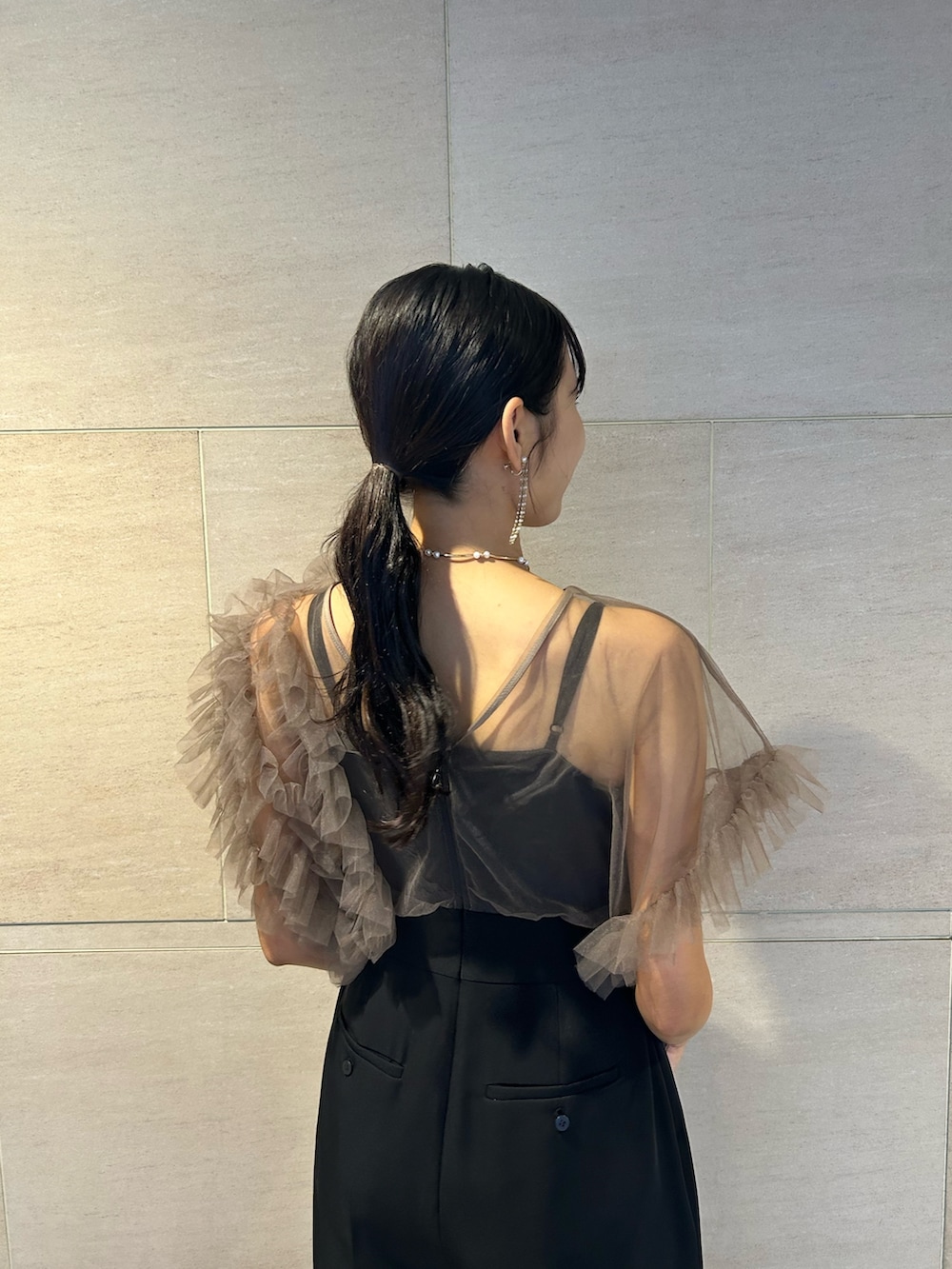 ゴールド系のクラッチバッグ、ブラック系のパンプス、その他のパンツドレスを着用したレディースの秋コーディネートの7枚目の写真