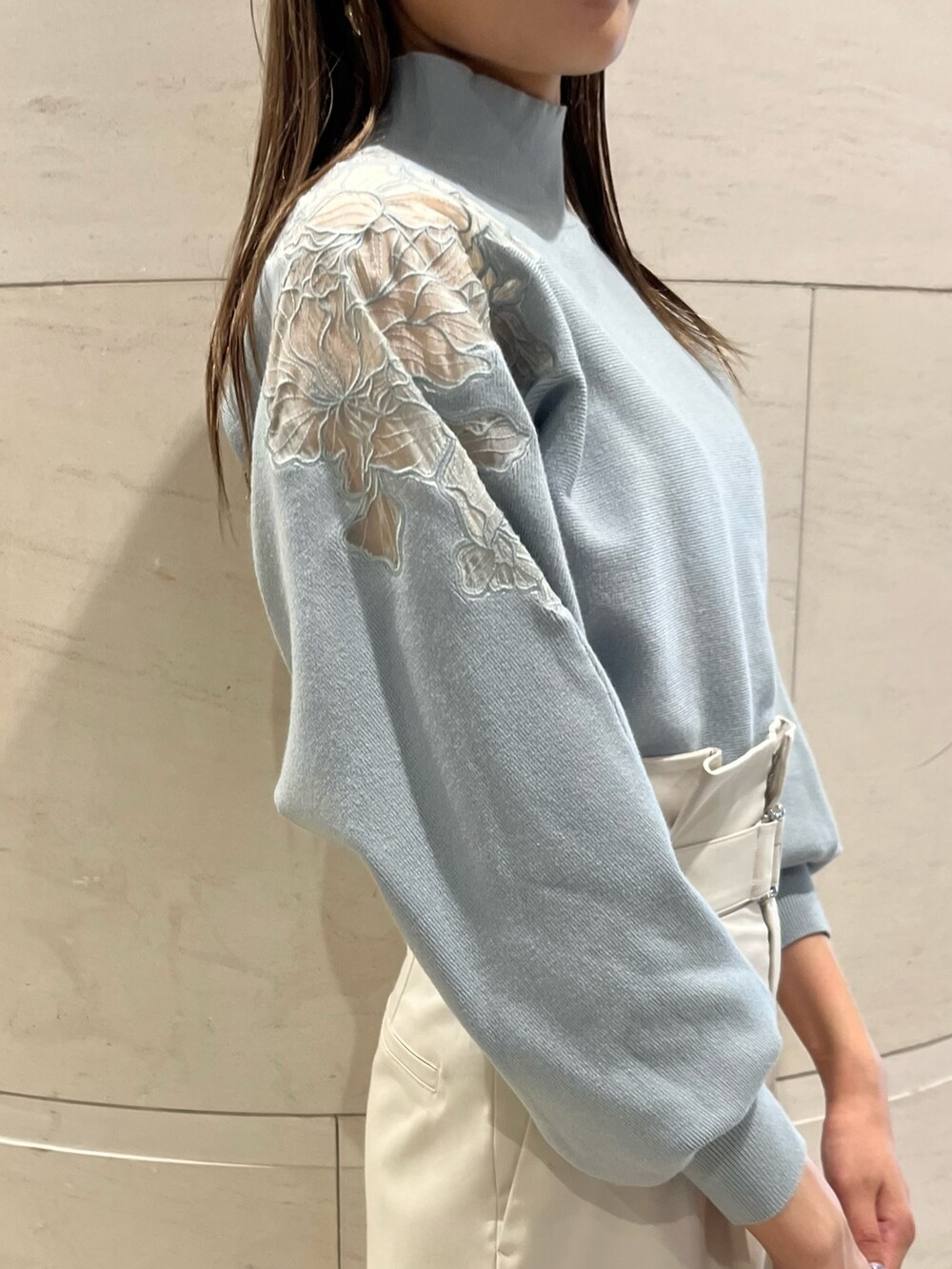 グリーン系のニット/セーター、ホワイト系のその他パンツ、ブラック系のハンドバッグを着用したレディースの秋コーディネートの6枚目の写真