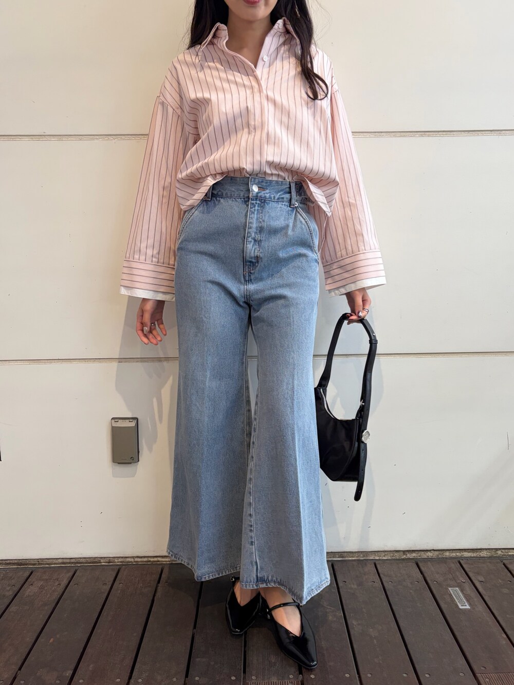 ピンク系のシャツ/ブラウス、ブルー系のデニムパンツ、ブラック系のハンドバッグを着用したレディースの春コーディネートの5枚目の写真